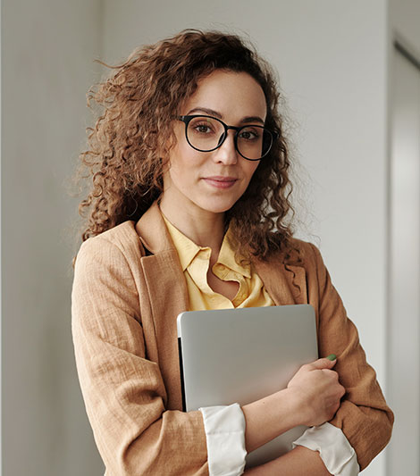 A woman smiling while looking at the camera while holding an office folder